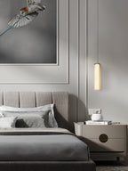 Clérachic Gleam pendant hanging over a nightstand in a panelled bedroom, leaving the surface below clear.