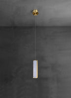 The Clérachic Gleam pendant with its compact brass ceiling canopy in view, wire dropping down grey plaster.