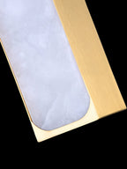 The Clérachic Gleam shade in close-up: milky alabaster veining set into a brushed brass edge.