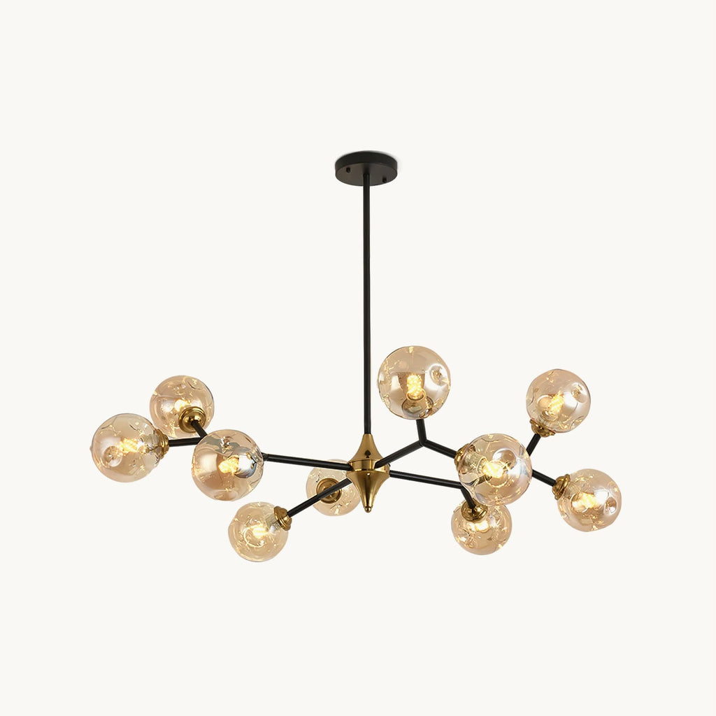 A branching black and gold chandelier with amber glass globes on a plain white backdrop, shown as this Clérachic ceiling light.