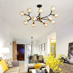 Amber Clérachic chandelier glows on the ceiling of an open living and dining space, with yellow flowers in the foreground.