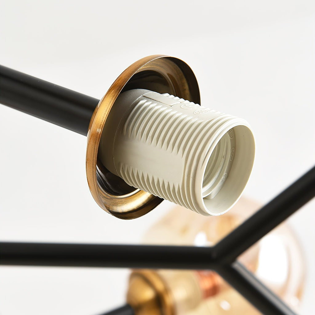 Close view of a white ribbed bulb socket in a brass collar at the end of a black arm on this Clérachic chandelier.