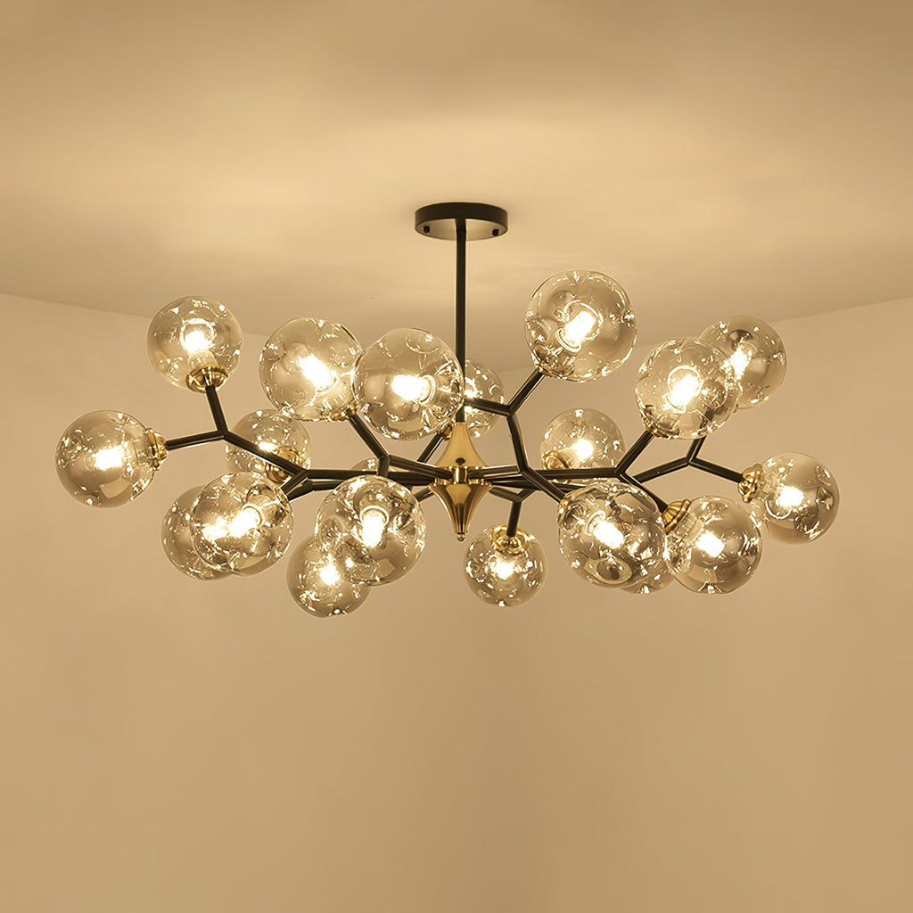 Seen from below, a full amber Clérachic chandelier glows with its globes clustered thickly around a brass hub.