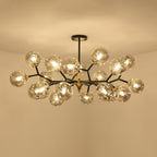 Seen from below, a full amber Clérachic chandelier glows with its globes clustered thickly around a brass hub.