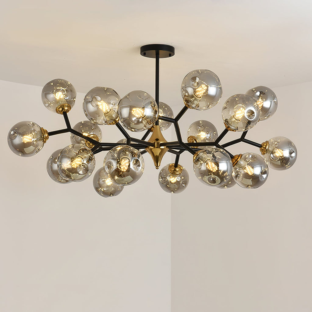 The fullest smoky grey Clérachic chandelier, lit, with clustered glass globes on black branches against a pale corner ceiling.