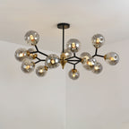 Smoky grey Clérachic chandelier with a double layer of globes on black arms, glowing against a plain pale ceiling.