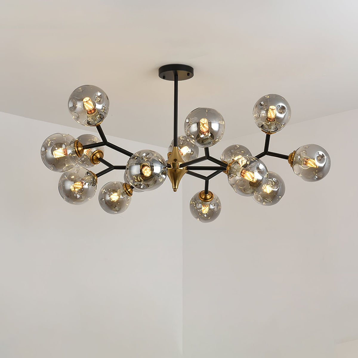 Smoky grey Clérachic chandelier with a double layer of globes on black arms, glowing against a plain pale ceiling.