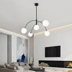 Black and white Clérachic chandelier in a lounge with a log-filled fireplace, its five frosted globes glowing.