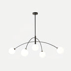 Black and white Clérachic chandelier on a pale grey backdrop, with a thin rod and five globes at different heights.