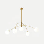 Gold and white Clérachic chandelier on a pale background, its brass rod and arms holding five soft white globes.
