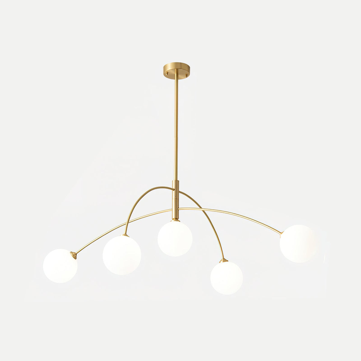 Gold and white Clérachic chandelier on a pale background, its brass rod and arms holding five soft white globes.