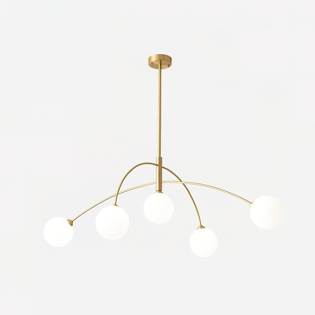Gold and white Clérachic chandelier with a brass ceiling cap and rod, five lit globes glowing on a soft white backdrop.
