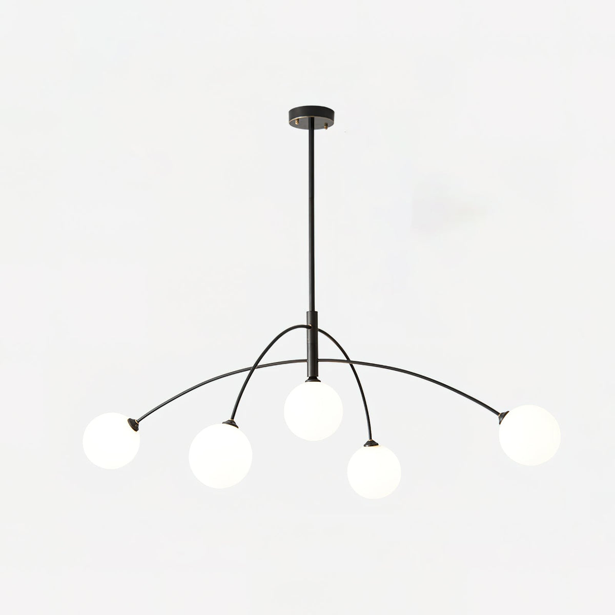 Black and white Clérachic chandelier with a black ceiling cap, lit globes and arms sweeping out to each side.