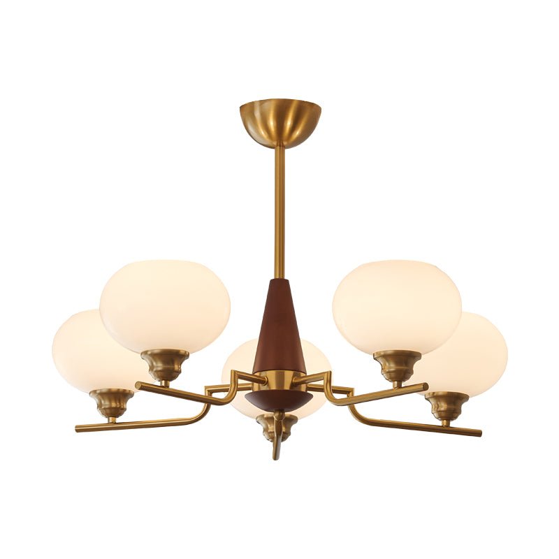 A five-light Clérachic chandelier with milky globes, brass arms and a walnut cone, on a plain white backdrop.