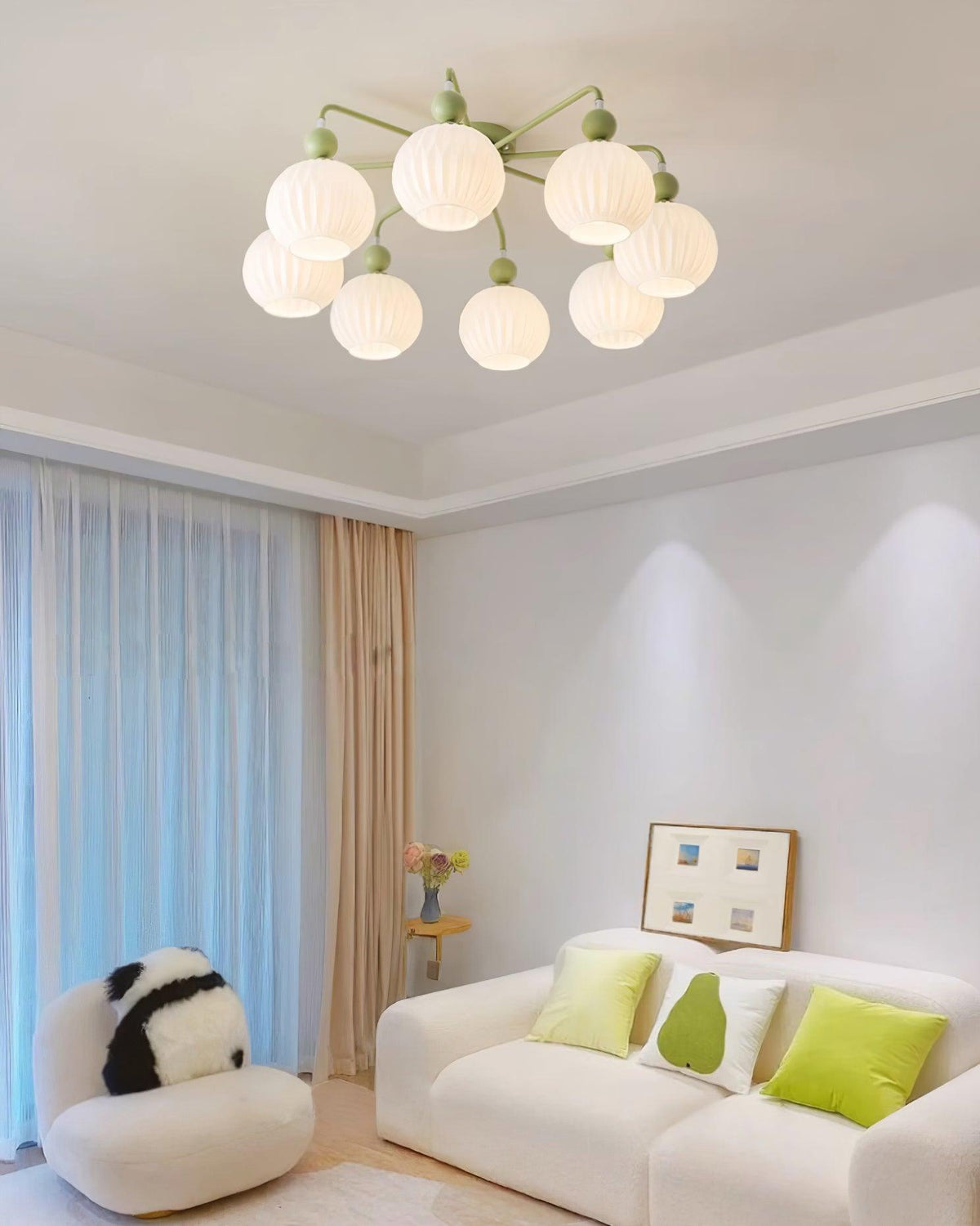 Green Clérachic ceiling light with eight ribbed globes, over a white sofa with lime cushions and a panda cushion chair.
