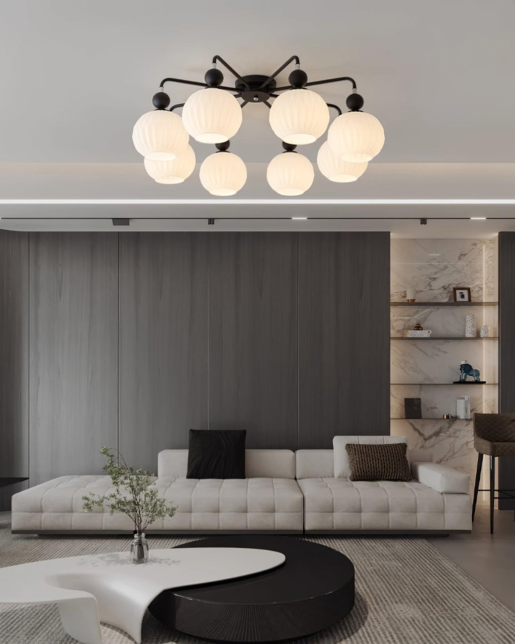 Clérachic flush-mount light with black arms above a tufted white sofa, a dark slatted wall and a curved coffee table.