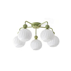 Five-globe green Clérachic ceiling light on white, showing the ribbed glass and the green wooden-look balls on each arm.
