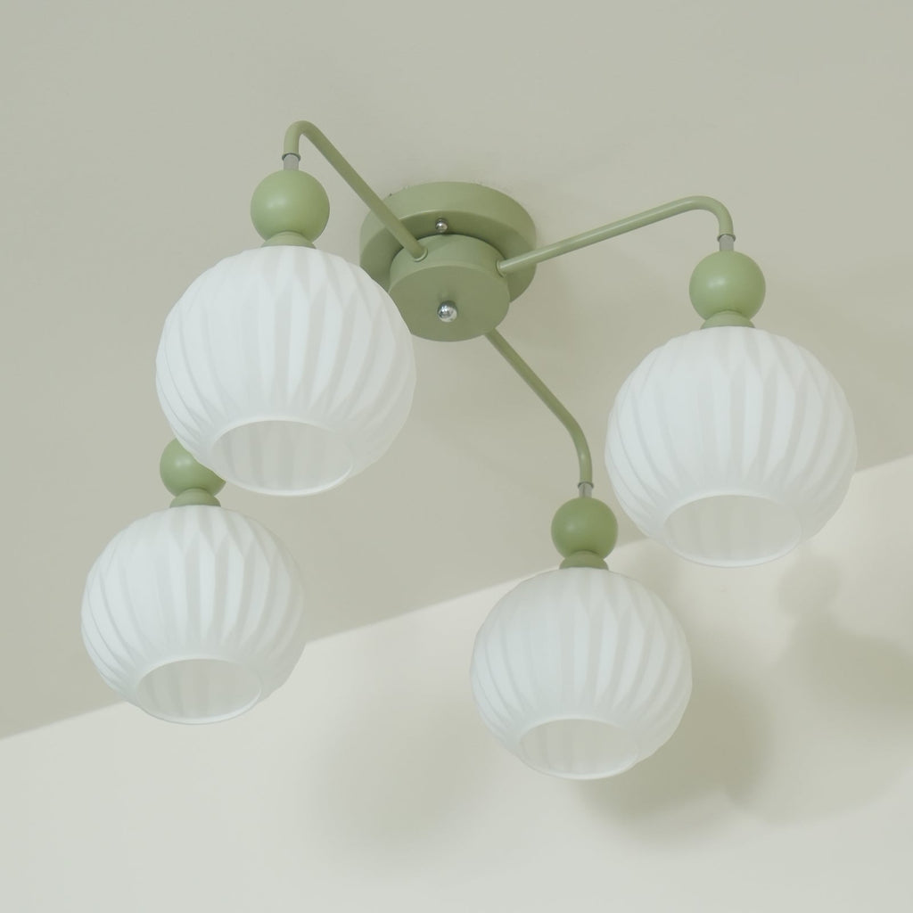 Underside view of the four-globe green Clérachic ceiling light, the ribbed white globes unlit against a pale wall.