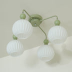 Underside view of the four-globe green Clérachic ceiling light, the ribbed white globes unlit against a pale wall.
