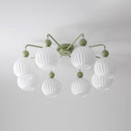 Eight-globe green Clérachic ceiling light seen from below, the ribbed white shades in two rings on a grey-white ceiling.