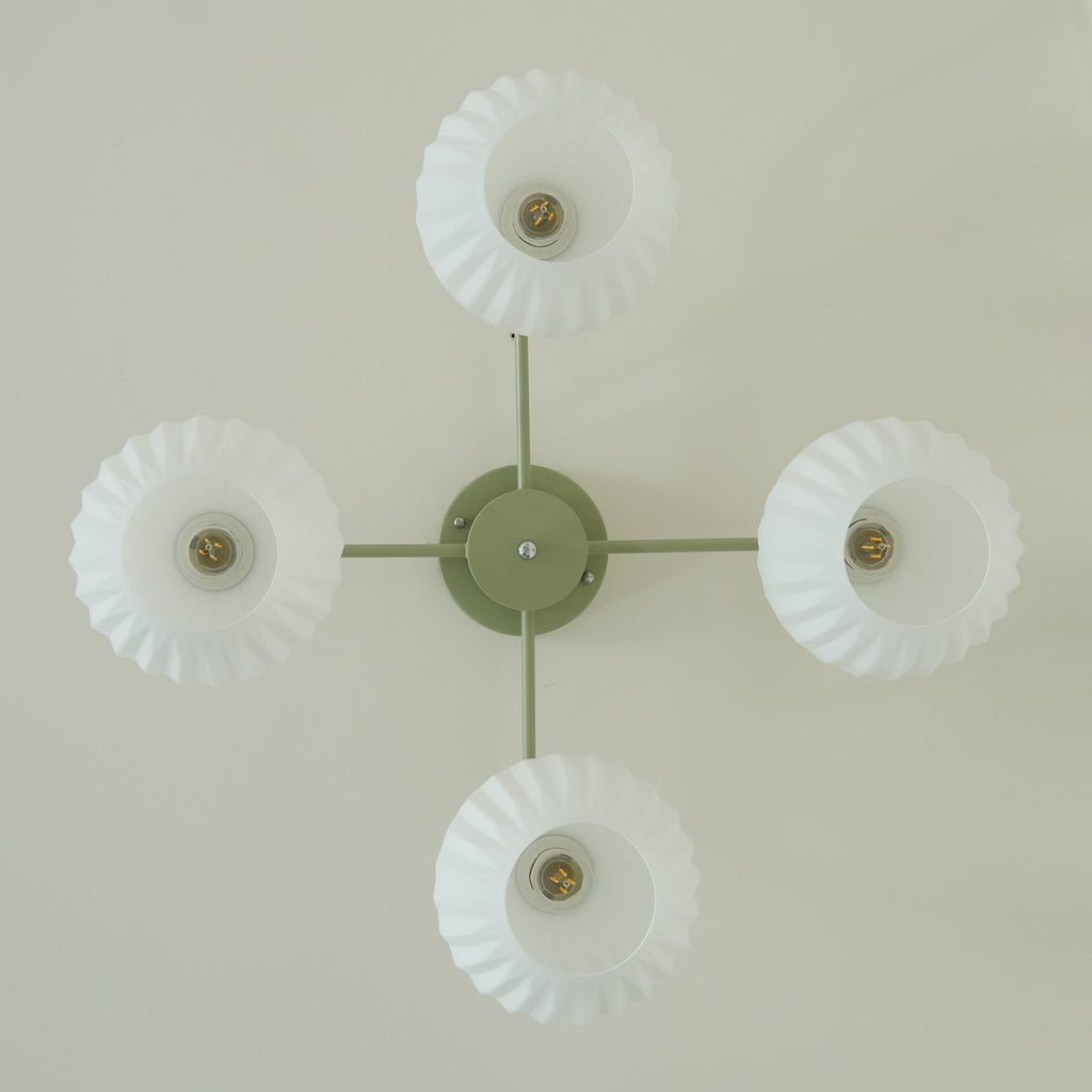 View straight up at the four-globe Clérachic ceiling light, with an open bulb visible inside each scalloped-edge shade.