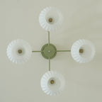 View straight up at the four-globe Clérachic ceiling light, with an open bulb visible inside each scalloped-edge shade.