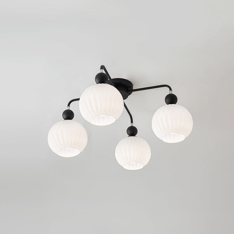 Four-globe Clérachic ceiling light with black arms and balls, its ribbed white globes unlit on a grey ceiling.