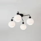 Four-globe Clérachic ceiling light with black arms and balls, its ribbed white globes unlit on a grey ceiling.