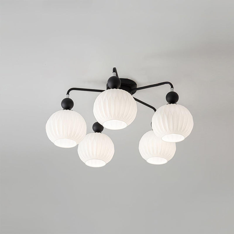 Five ribbed white globes on black curved arms, on a Clérachic ceiling light photographed from below.