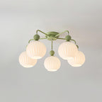 A five-globe Clérachic ceiling light in green, switched on, the ribbed glass glowing evenly on a soft grey ceiling.