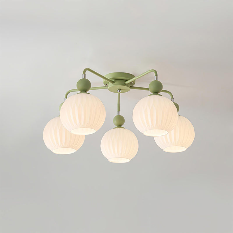 A five-globe Clérachic ceiling light in green, switched on, the ribbed glass glowing evenly on a soft grey ceiling.