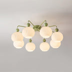 Green Clérachic ceiling light with eight globes, lit warm, the shades in two tiers around a round canopy.