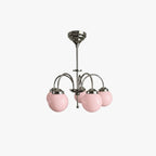 A Clérachic chandelier with five pink glass globes on curved polished metal arms, shown on a plain white backdrop.