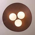 Looking up at the underside of this Clérachic pendant, with three opal globes in a triangle beneath the round, linen-textured brown shade.