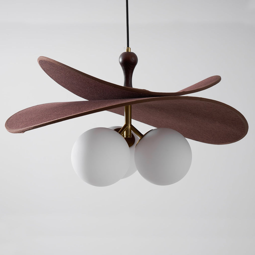 Close view of a Clérachic pendant unlit, with brown petals above three matt white globes on a brass arm.