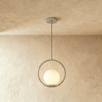 Clérachic silver ring pendant with a white opal glass globe set low in the ring, hung on a cord in a studio