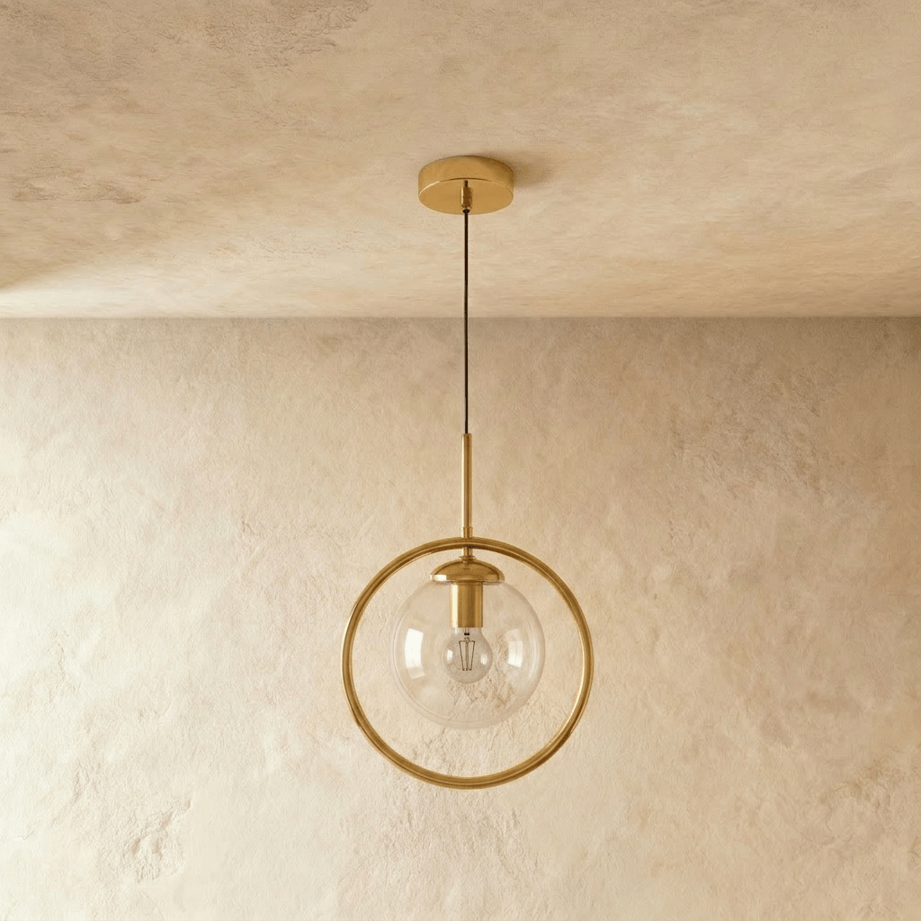 Clérachic gold ring pendant with a clear glass globe and a visible filament bulb on a slim rod, shown unlit in a studio
