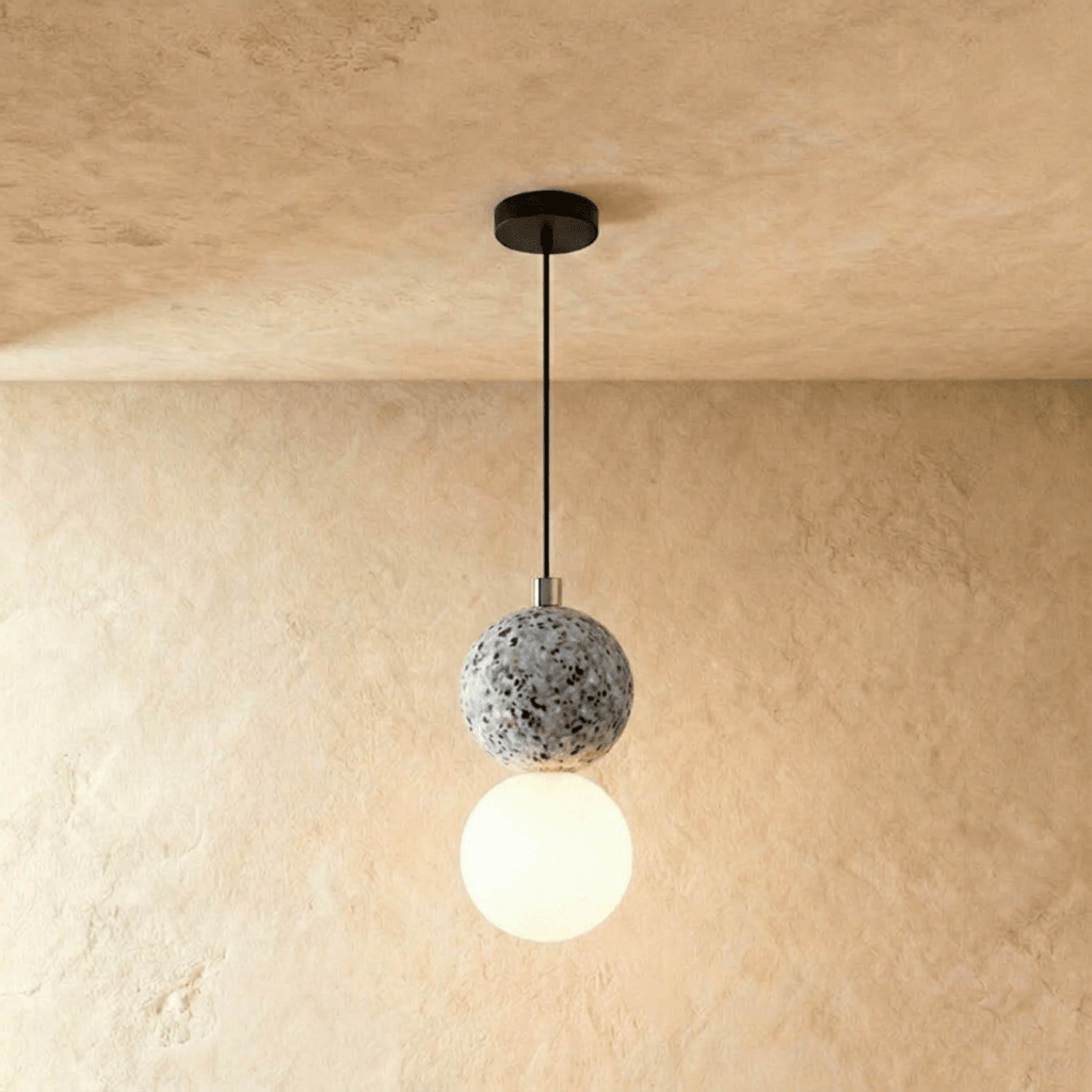 Clérachic two-globe pendant light with a grey terrazzo sphere above a glowing opal glass globe on a slim black cord.