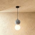 Clérachic two-globe pendant light with a grey terrazzo sphere above a glowing opal glass globe on a slim black cord.