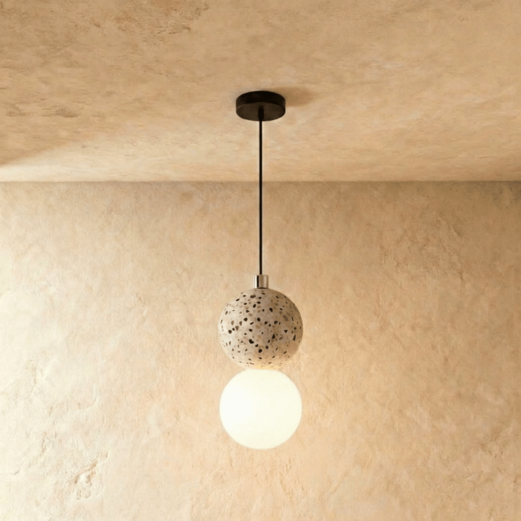 Clérachic two-globe pendant light with a cream terrazzo sphere above a glowing opal glass globe, hung on a black cord.