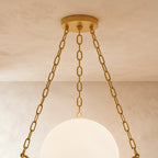 Close view of the Clérachic brass canopy and three chains above the glowing alabaster globe