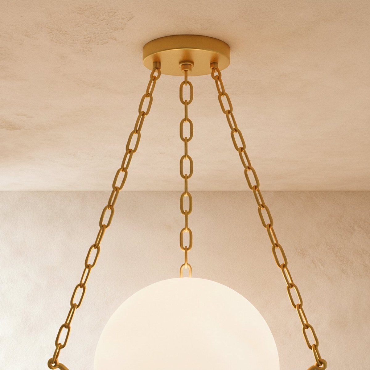 Close view of the Clérachic brass canopy and three chains above the glowing alabaster globe