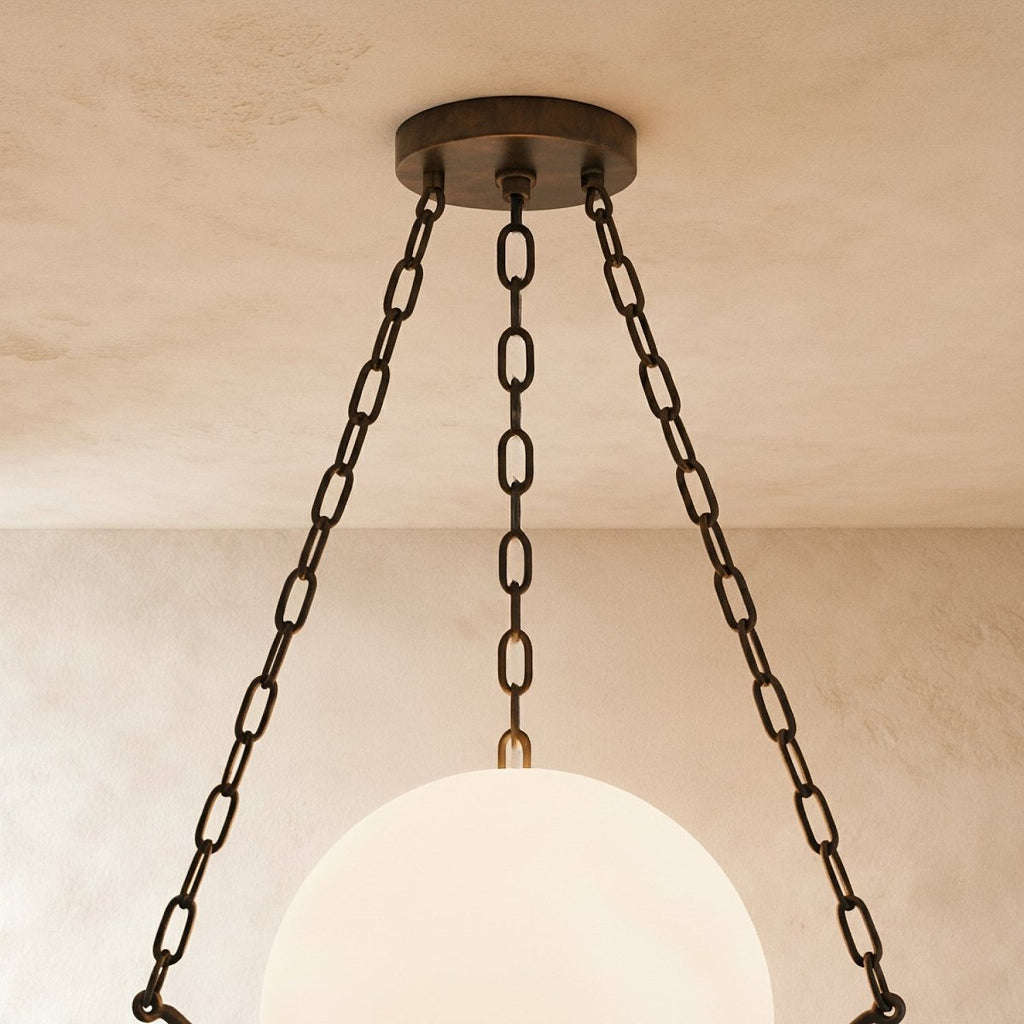 Close view of the Clérachic bronze canopy and three dark chains above the glowing alabaster globe