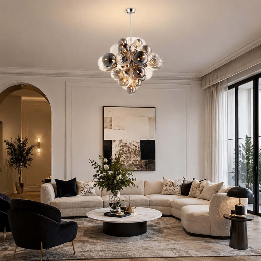 This Clérachic globe chandelier hangs in a tall living room with an arched doorway, above a round table and a cream corner sofa.