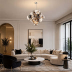 This Clérachic globe chandelier hangs in a tall living room with an arched doorway, above a round table and a cream corner sofa.