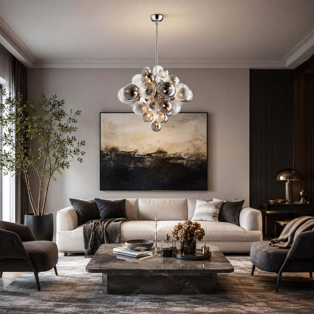 Smoked-glass Clérachic chandelier above a stone coffee table and cream sofa, in a room with a dark abstract painting.