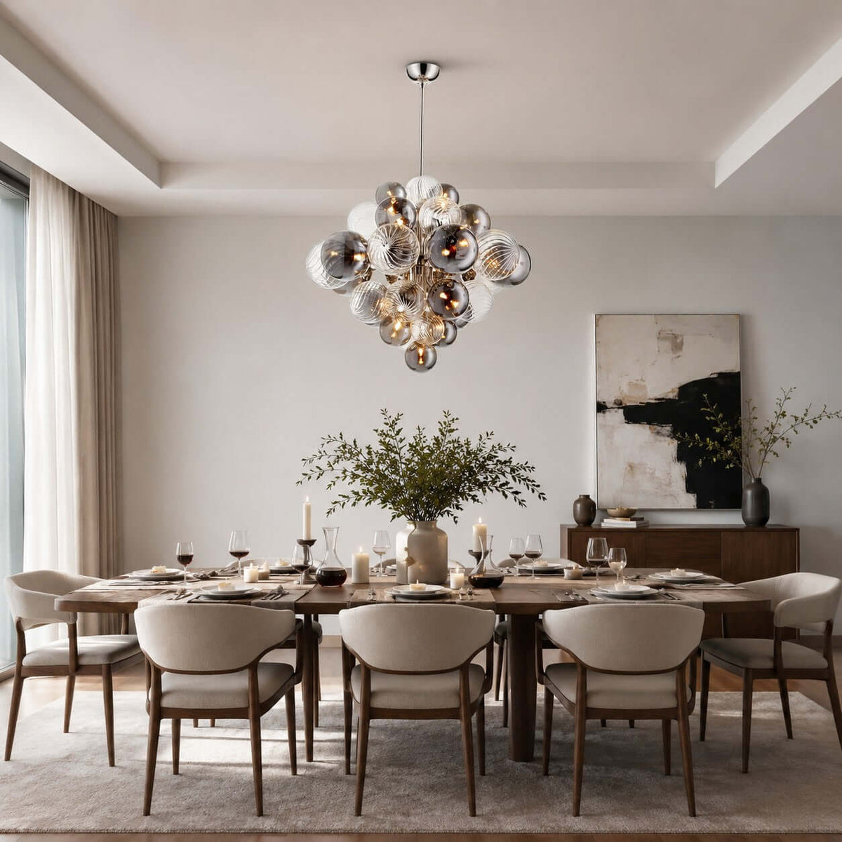 Clérachic cluster chandelier of smoked and ribbed globes above a long, laid dining table with cream curved-back chairs.