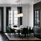Three Clérachic globe pendants hang near tall windows above a long dining table in a white room with ornate plaster ceilings.