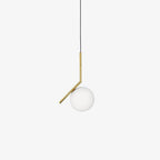 A small Clérachic globe pendant in frosted glass hangs from a thin black cord and a short brass stem on a white backdrop.