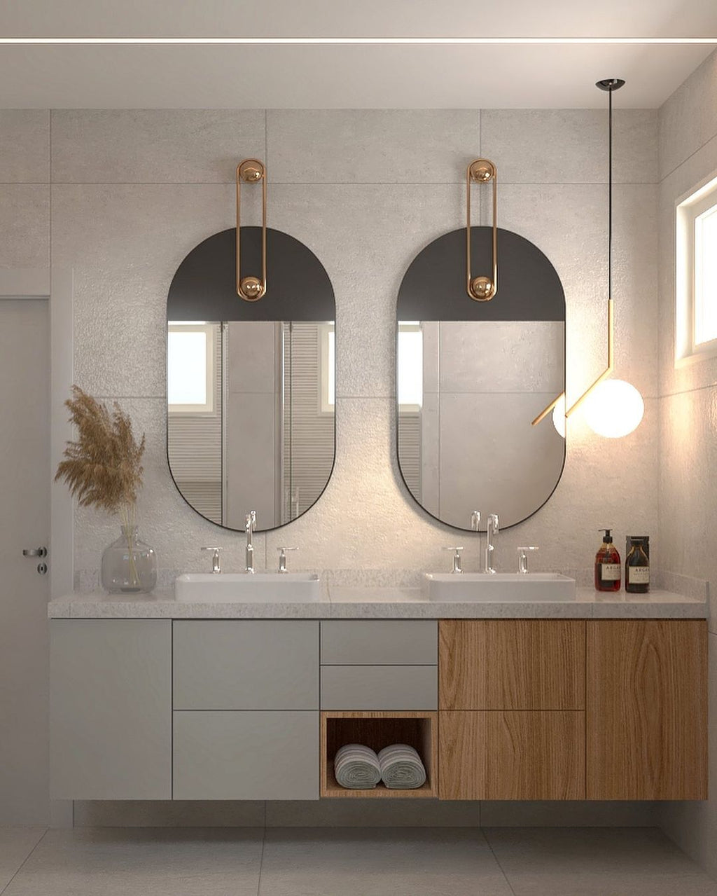 Over a bathroom vanity with two oval mirrors, a Clérachic globe pendant with a thin cord hangs near the right-hand wall.